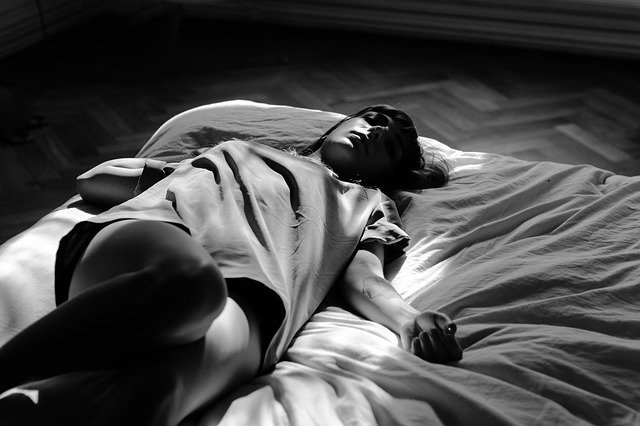 žena na posteli, černobílé