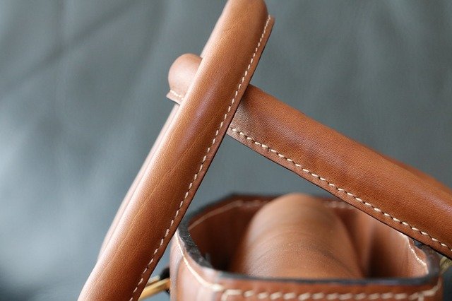 Detail uší hnědé kožené kabelky